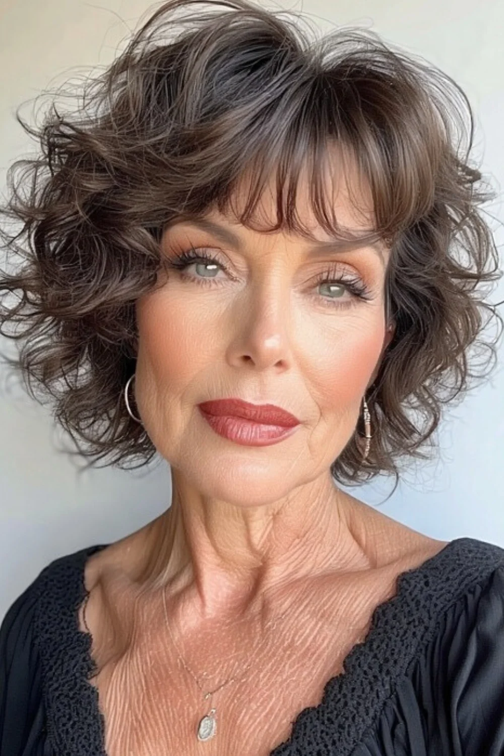 Trendy short curly bob haircut enhanced with textured layers 