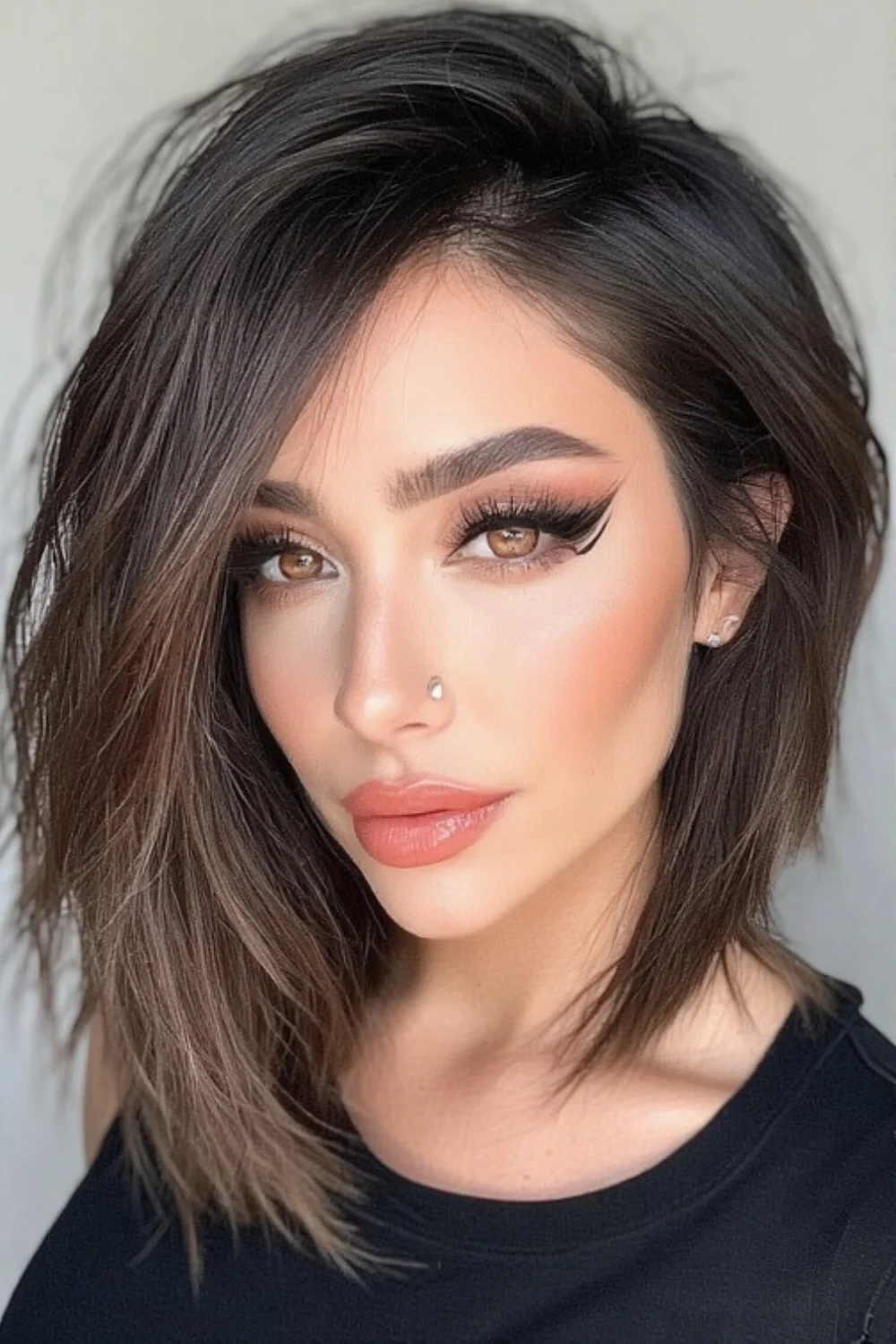 Layered haircut paired with side-swept bangs framing the face