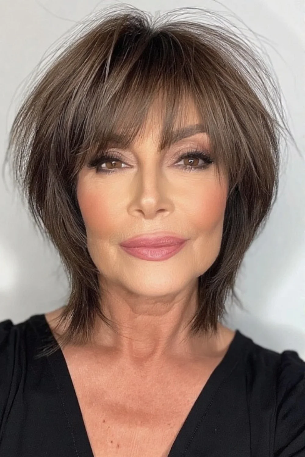 Longer pixie cut with layered texture and bangs
