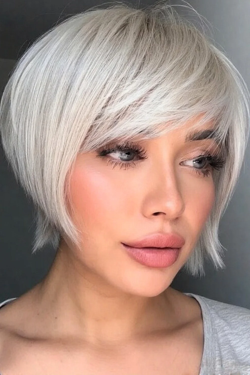 Soft pixie bob paired with curtain bangs for a gentle frame. 