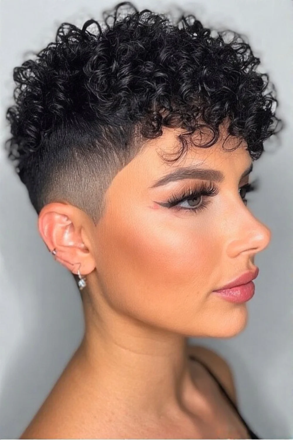 Pixie cut featuring tight curls and an undercut
