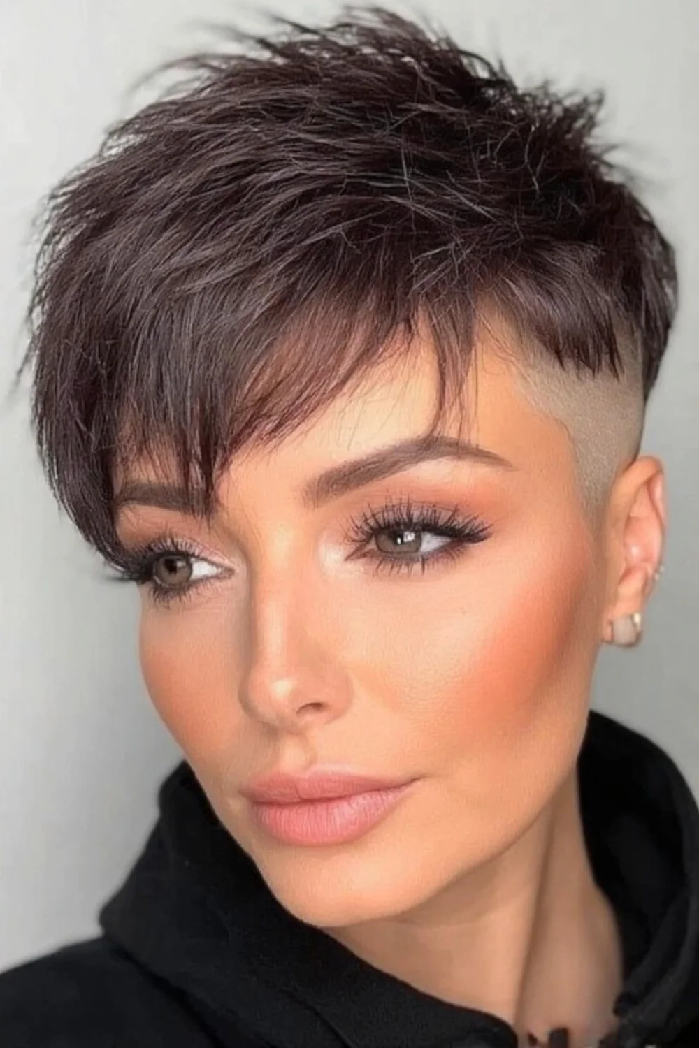 Bold undercut pixie haircut featuring layered texture